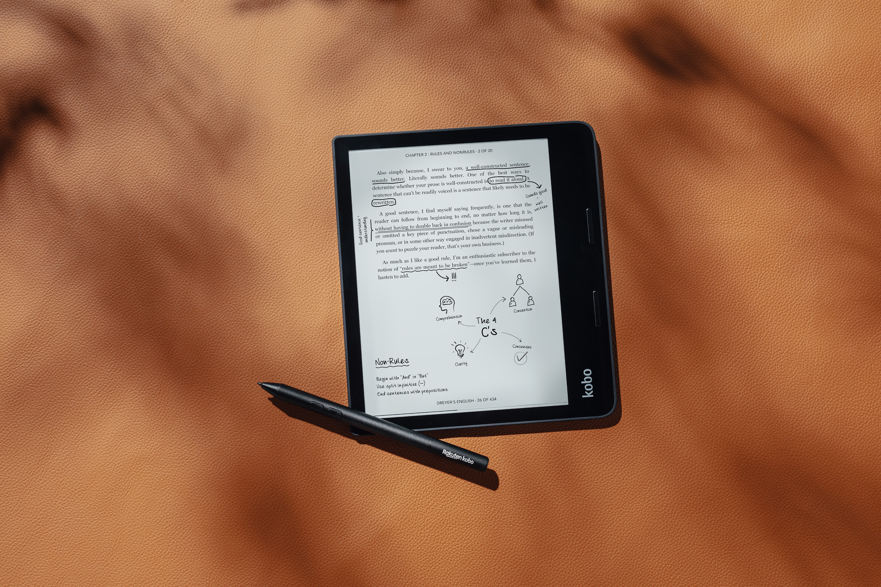E-Reader mit Text und Stift auf brauner Oberfläche.