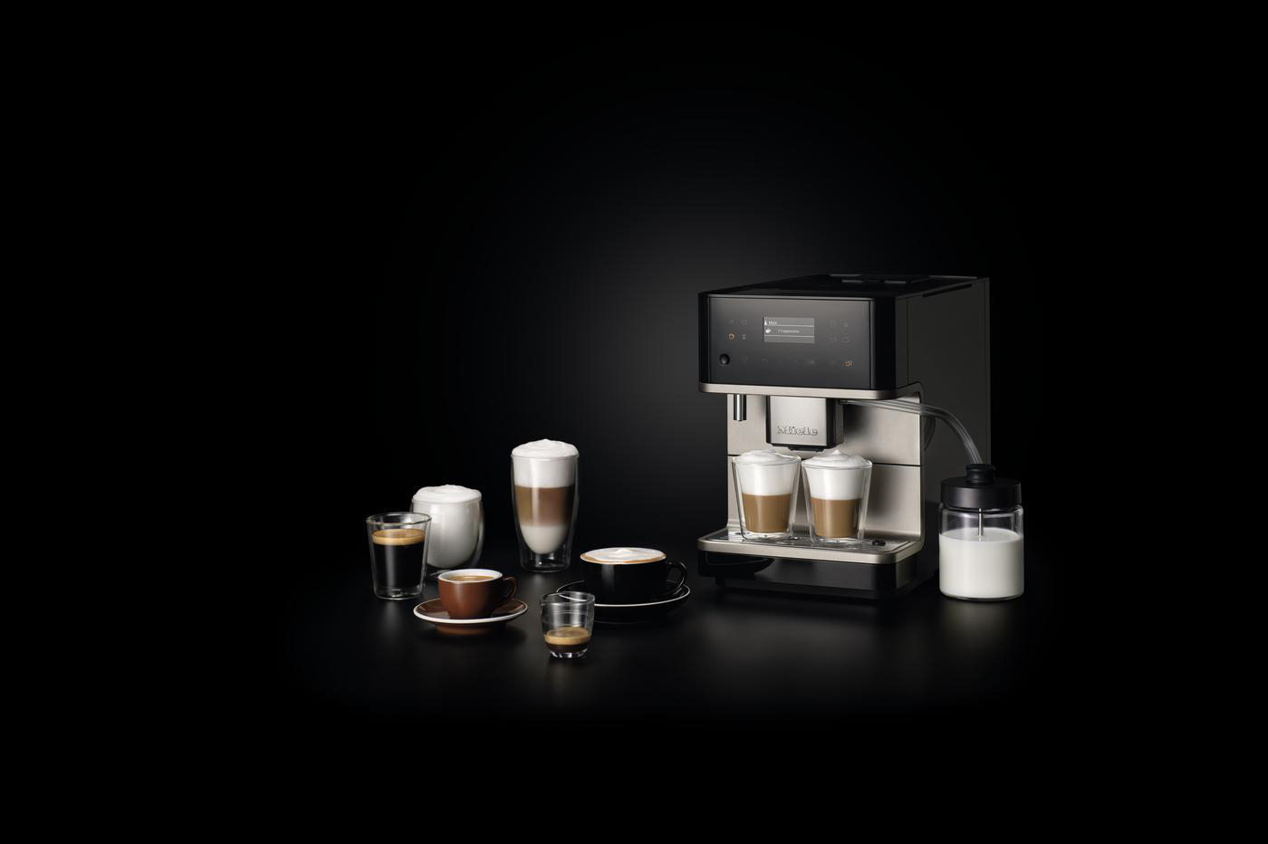 Espressomaschine mit Milchaufschäumer. Mehrere Kaffeegetränke sind darum herum angeordnet.