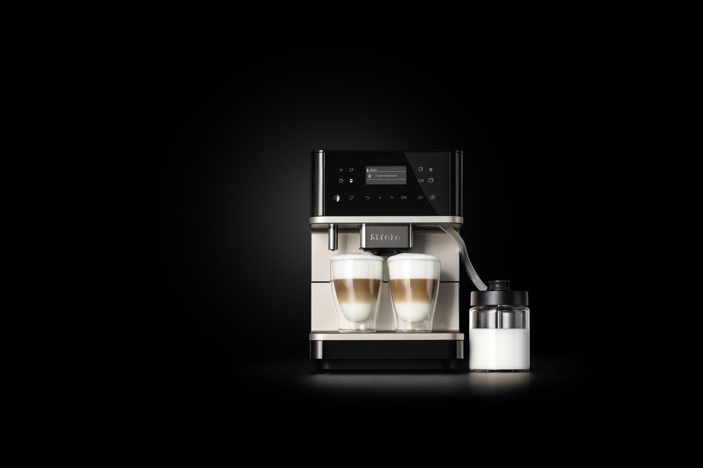 Eine Miele Kaffeemaschine mit zwei Latte Macchiato Gläsern und einem Milchbehälter.