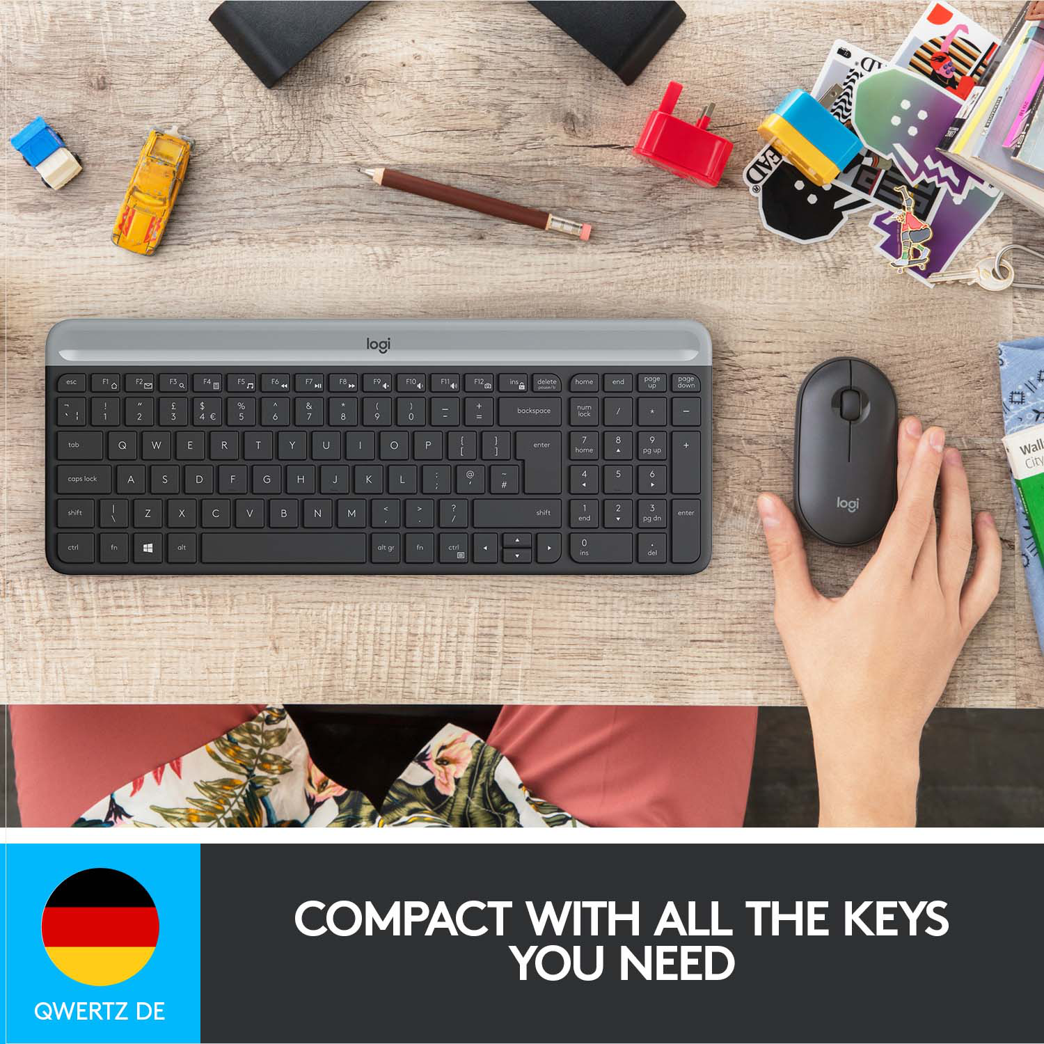 Personne utilisant un clavier et une souris sur un bureau en bois. Il y a d'autres objets.
