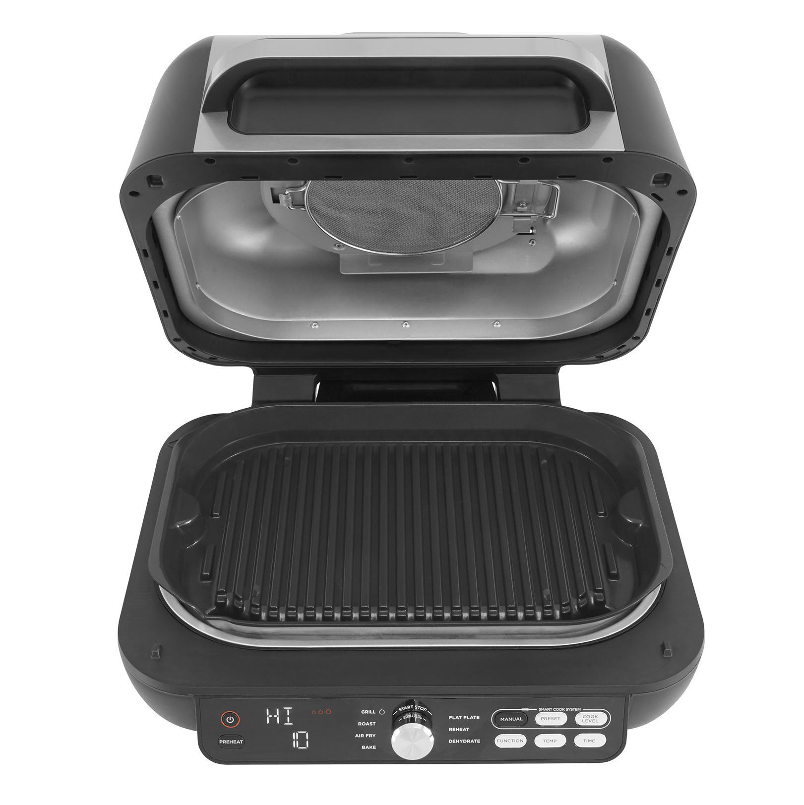 Ein offener schwarzer Grill mit silbernem Einsatz und Bedienfeld.