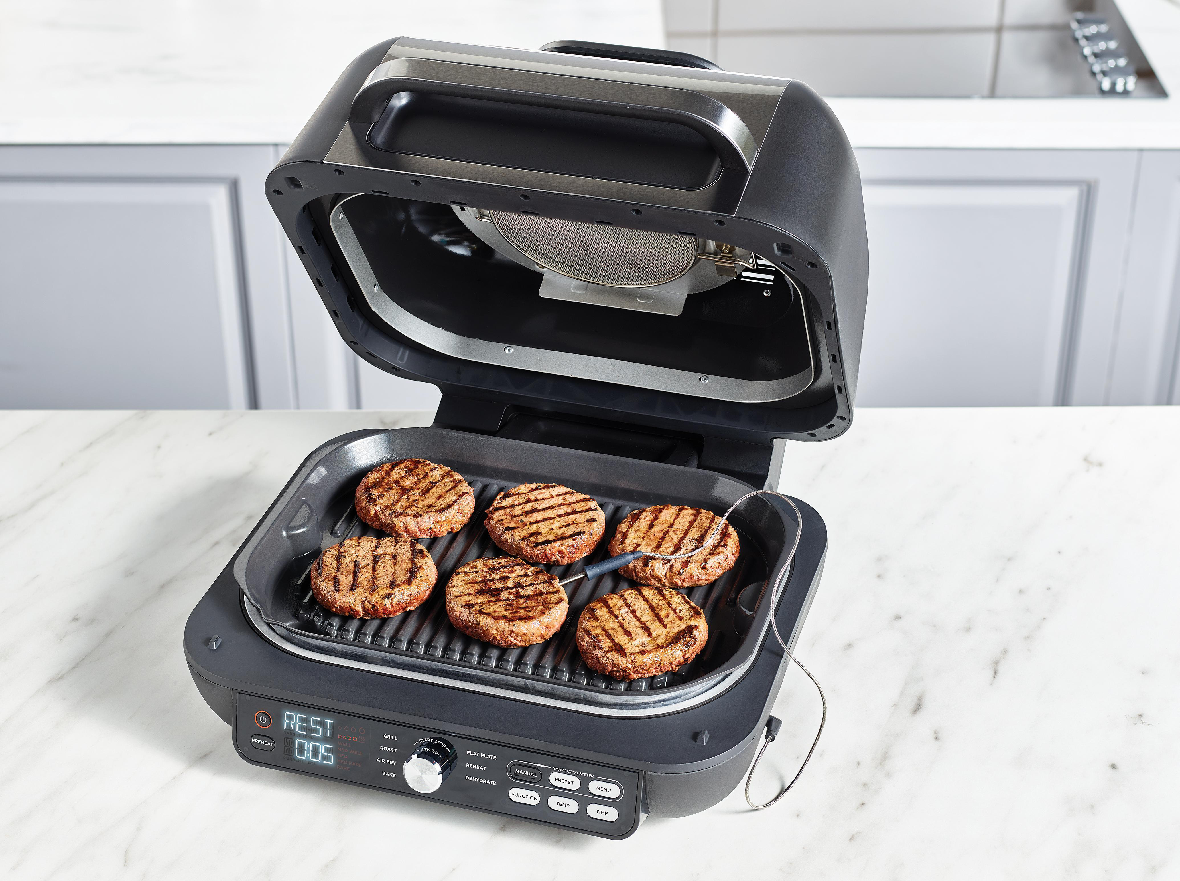 Sechs Burger werden auf einem Grill mit einem Thermometer gegrillt.