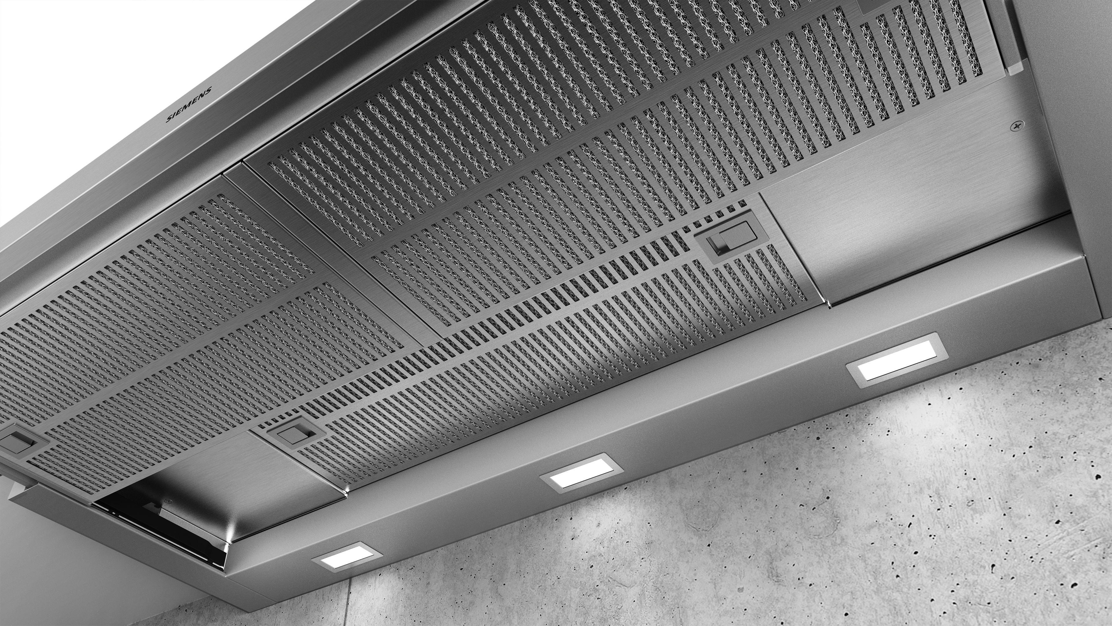 Hotte en acier inoxydable avec lumières. Le fond est un mur en béton gris clair.