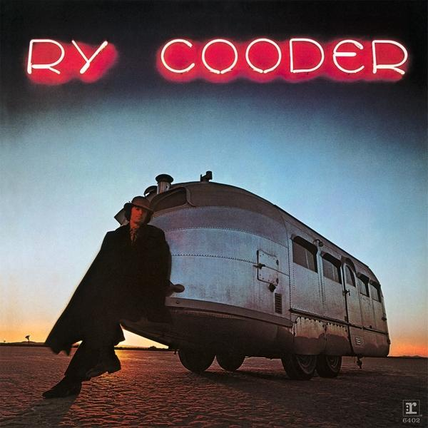 Ry Cooder albumborítója neonfelirattal és egy férfi, aki egy vonat szerű járműnek támaszkodik a sivatagban.