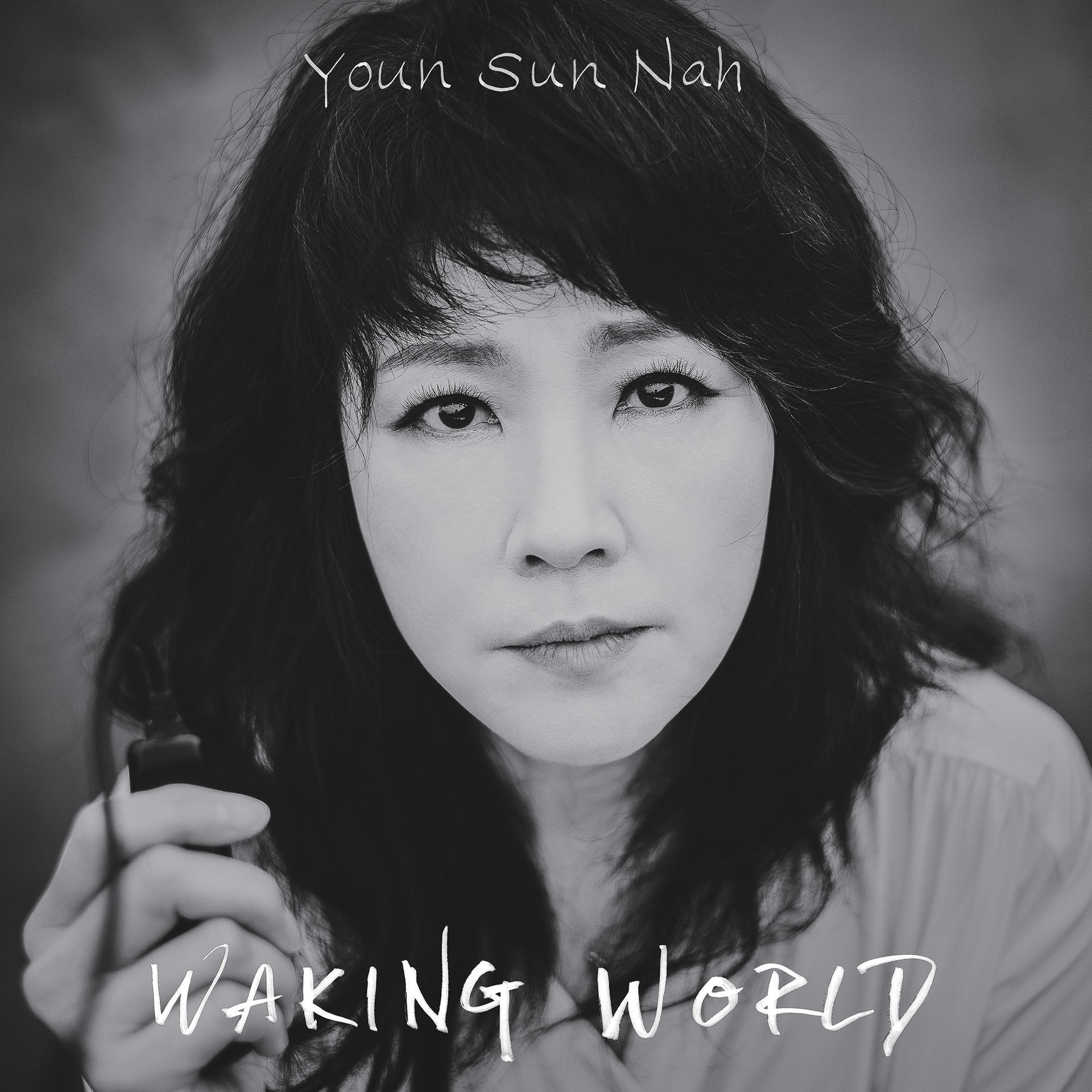 Schwarzweiß-Porträt von Youn Sun Nah, Blick in die Kamera, Text "Waking World".