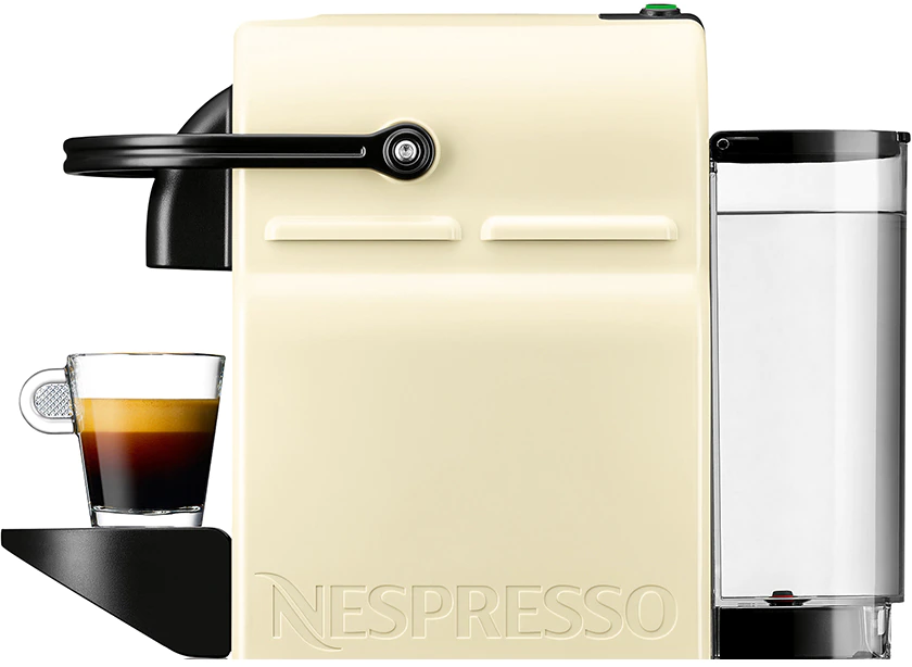 Egy fehér Nespresso gép fekete fogantyúval és egy pohár eszpresszóval.