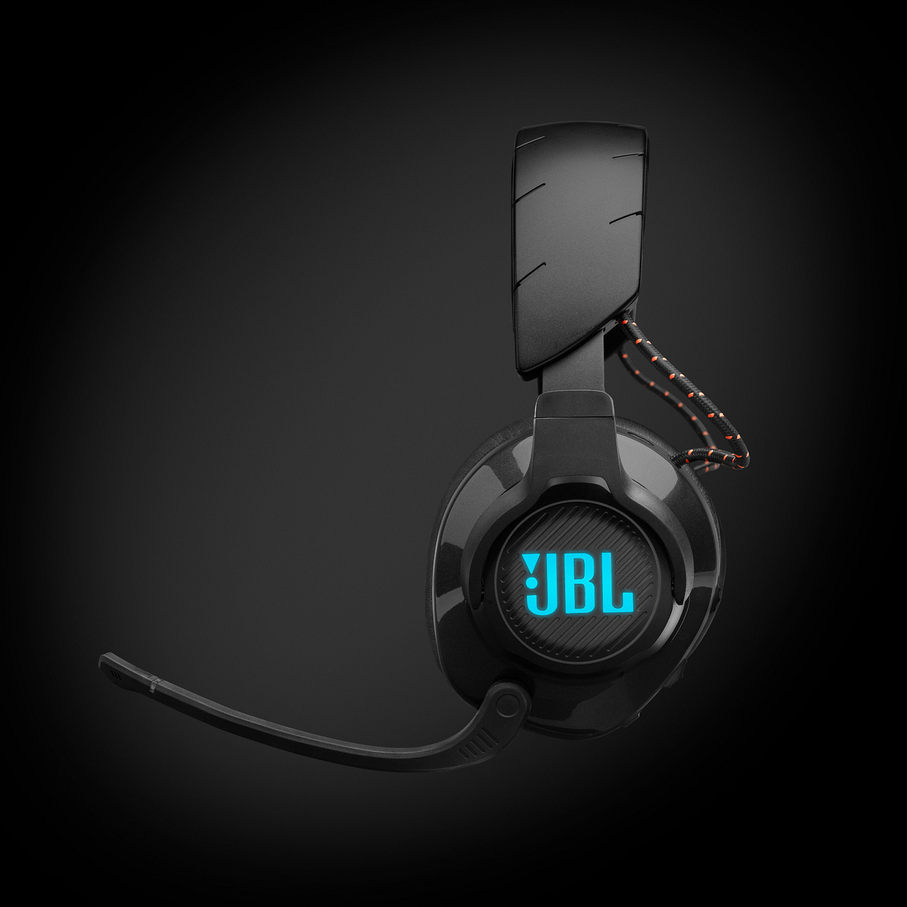 Schwarzes JBL Gaming-Headset mit Mikrofon. Blaues JBL-Logo auf dem Ohrmuschel, dunkler Hintergrund.