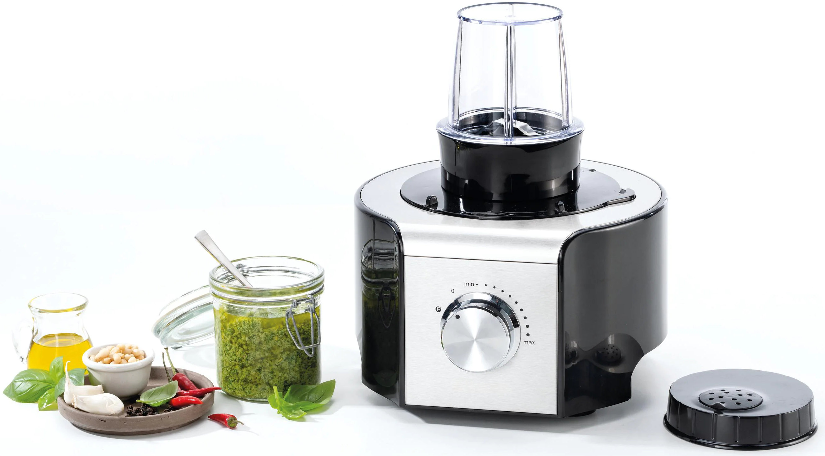 Küchenmaschine mit Pesto-Zutaten, darunter Basilikum, Öl und Pinienkerne.