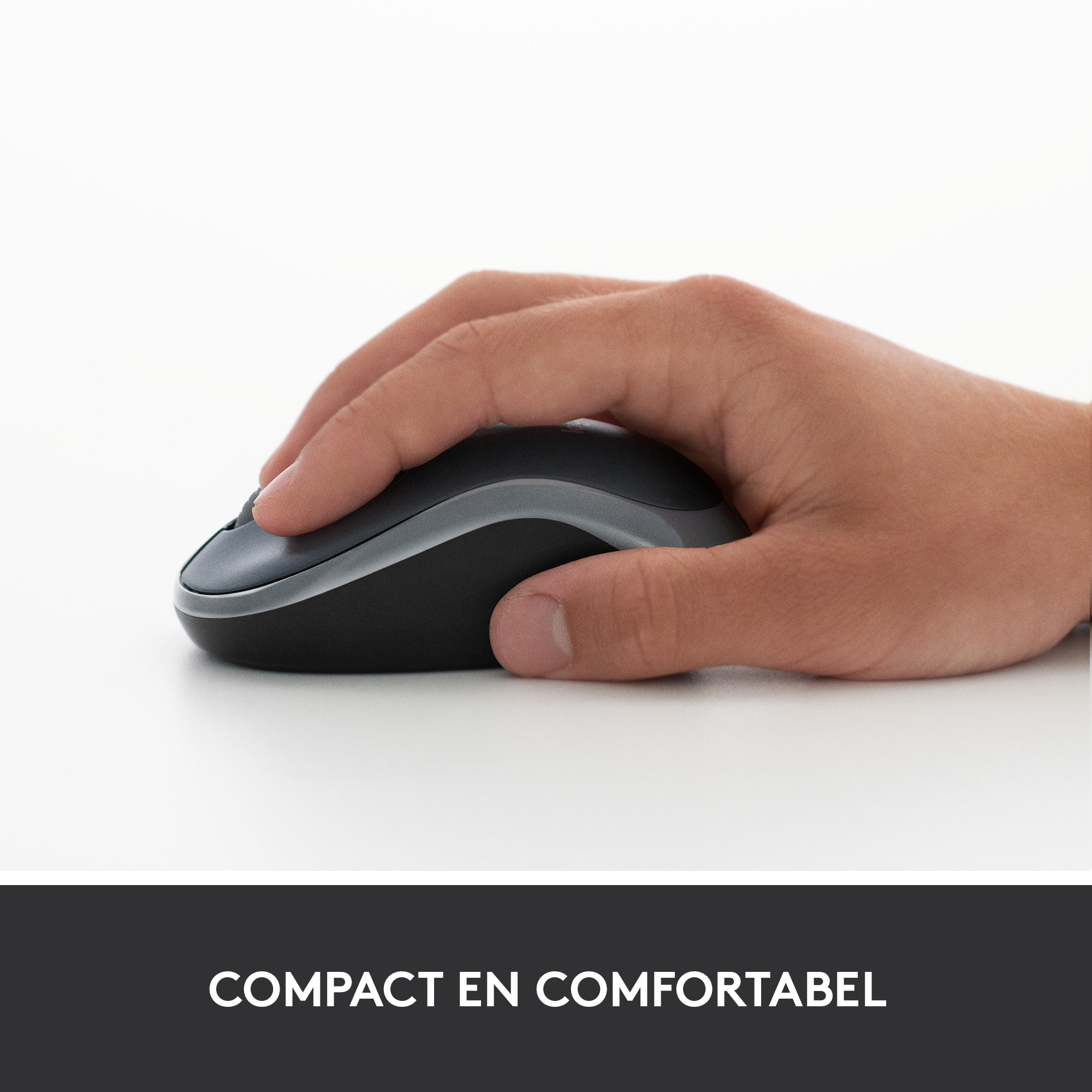 Hand die een zwarte en grijze computermuis vasthoudt op een wit oppervlak. Het woord 'Compact' staat eronder.