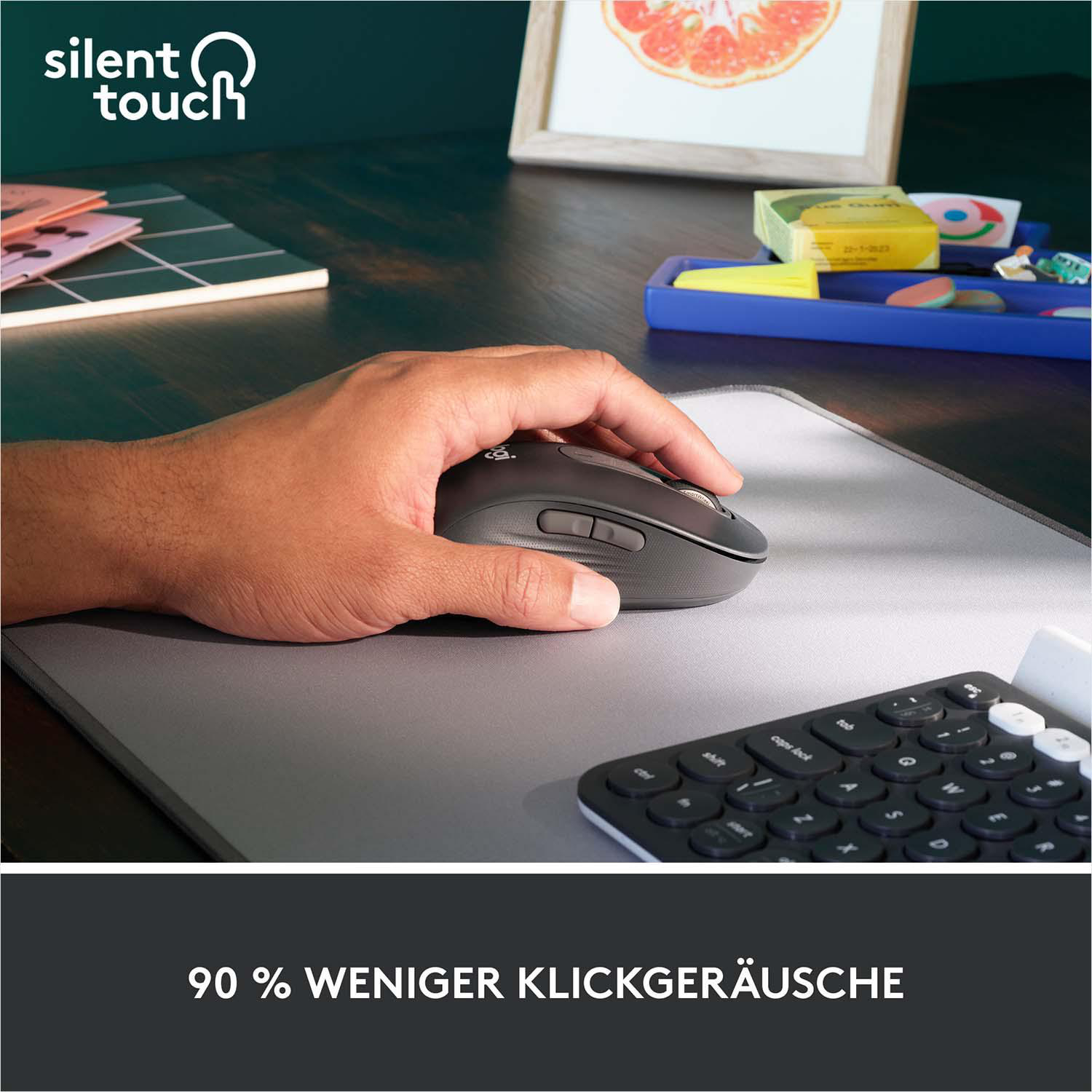Eine Person benutzt eine dunkelgraue Maus auf einem Mauspad neben einer Tastatur.