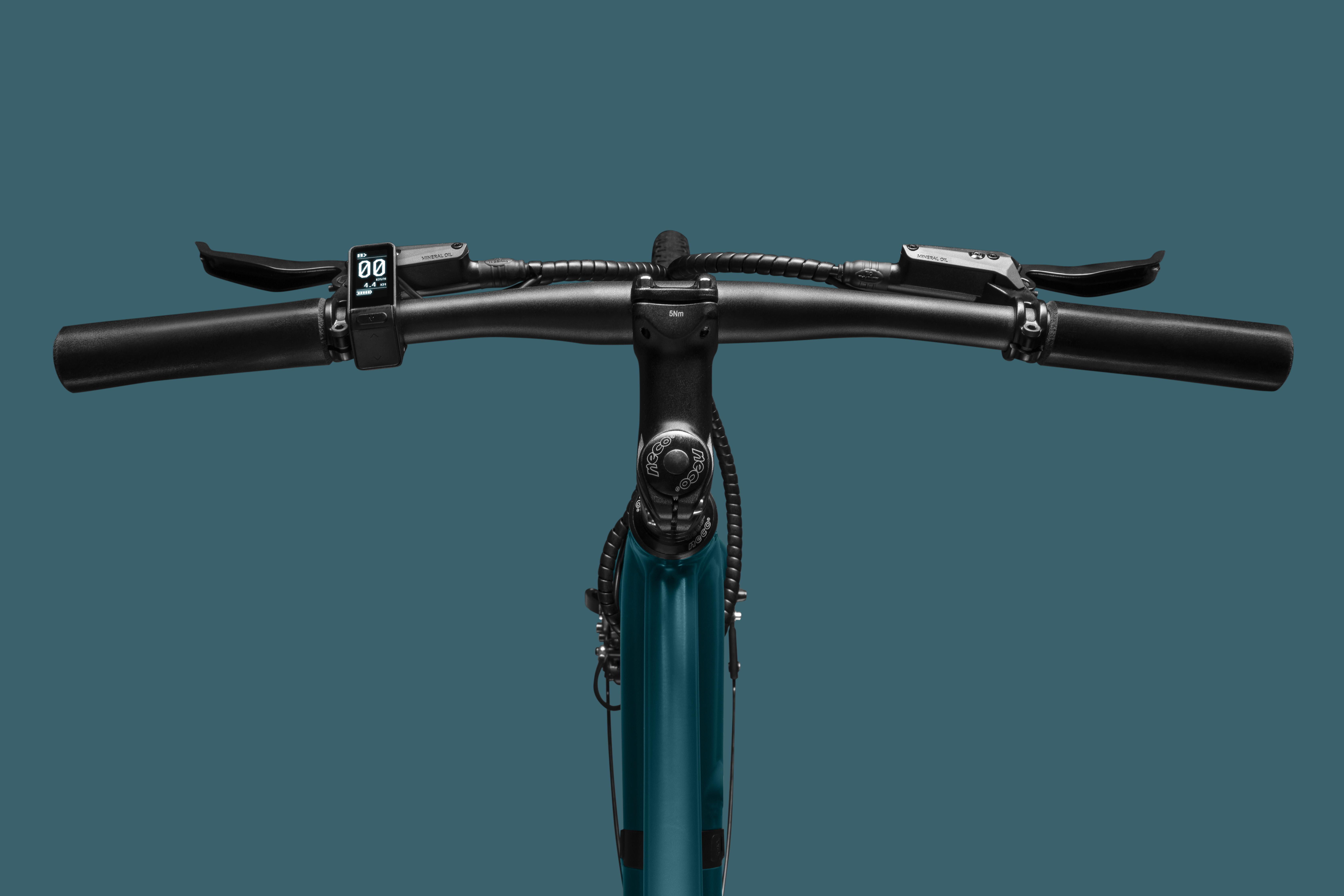 Nahaufnahme eines tealfarbenen Fahrradlenkers mit blauem Hintergrund.