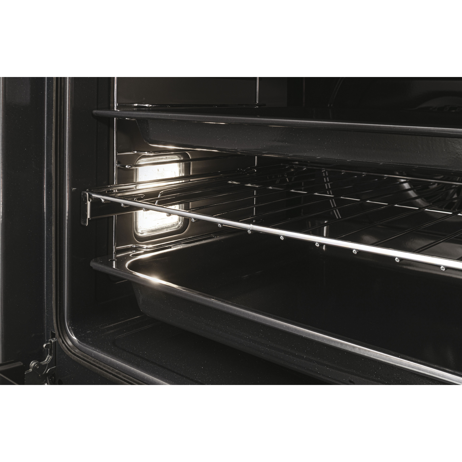 Vista interior de un horno. Se ven rejillas metálicas y una bandeja para hornear. La luz está encendida.