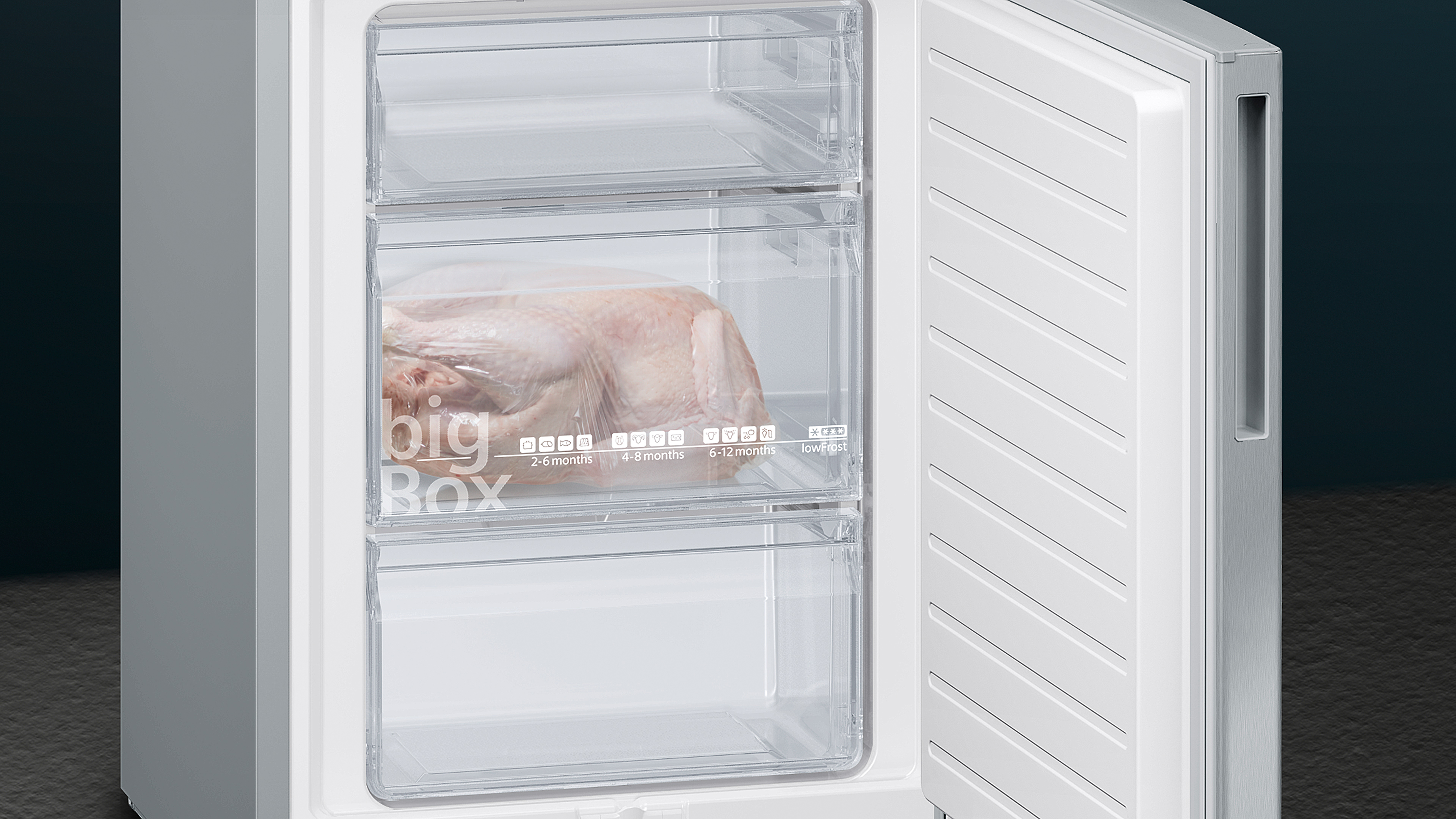 Ein Gefrierschrank mit offener Tür, der transparente Schubladen mit einer Pute zeigt.