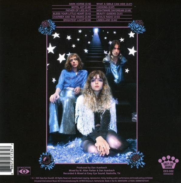 Pochette d'album avec un groupe de trois personnes. Une femme est agenouillée. Le fond est un escalier et des étoiles.