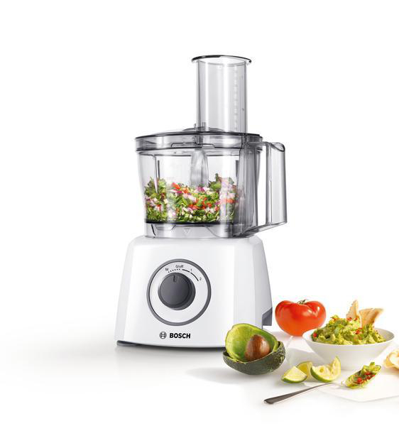 Küchenmaschine mit gehacktem Gemüse und Guacamole, mit Avocado und Tomaten.