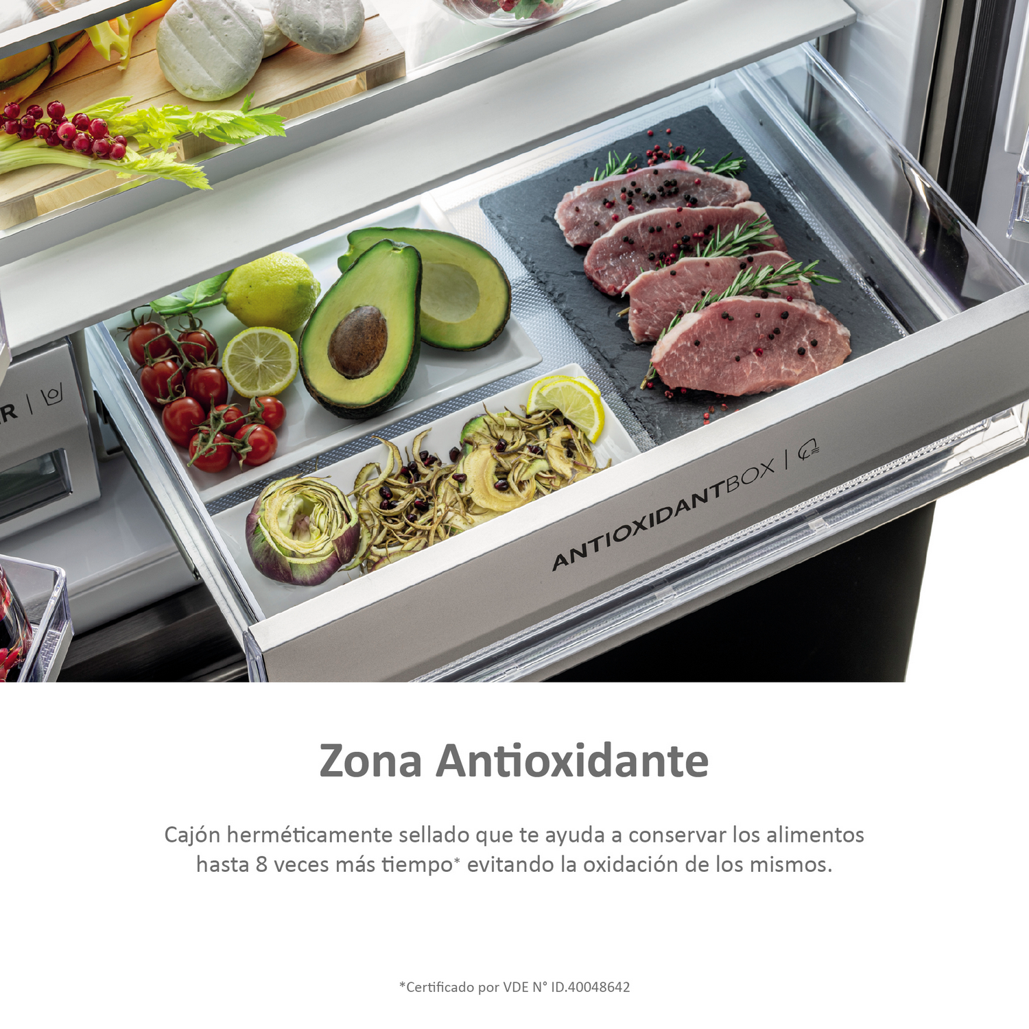 Cajón de refrigerador abierto con comida dentro. Se muestran frutas, verduras y carnes.
