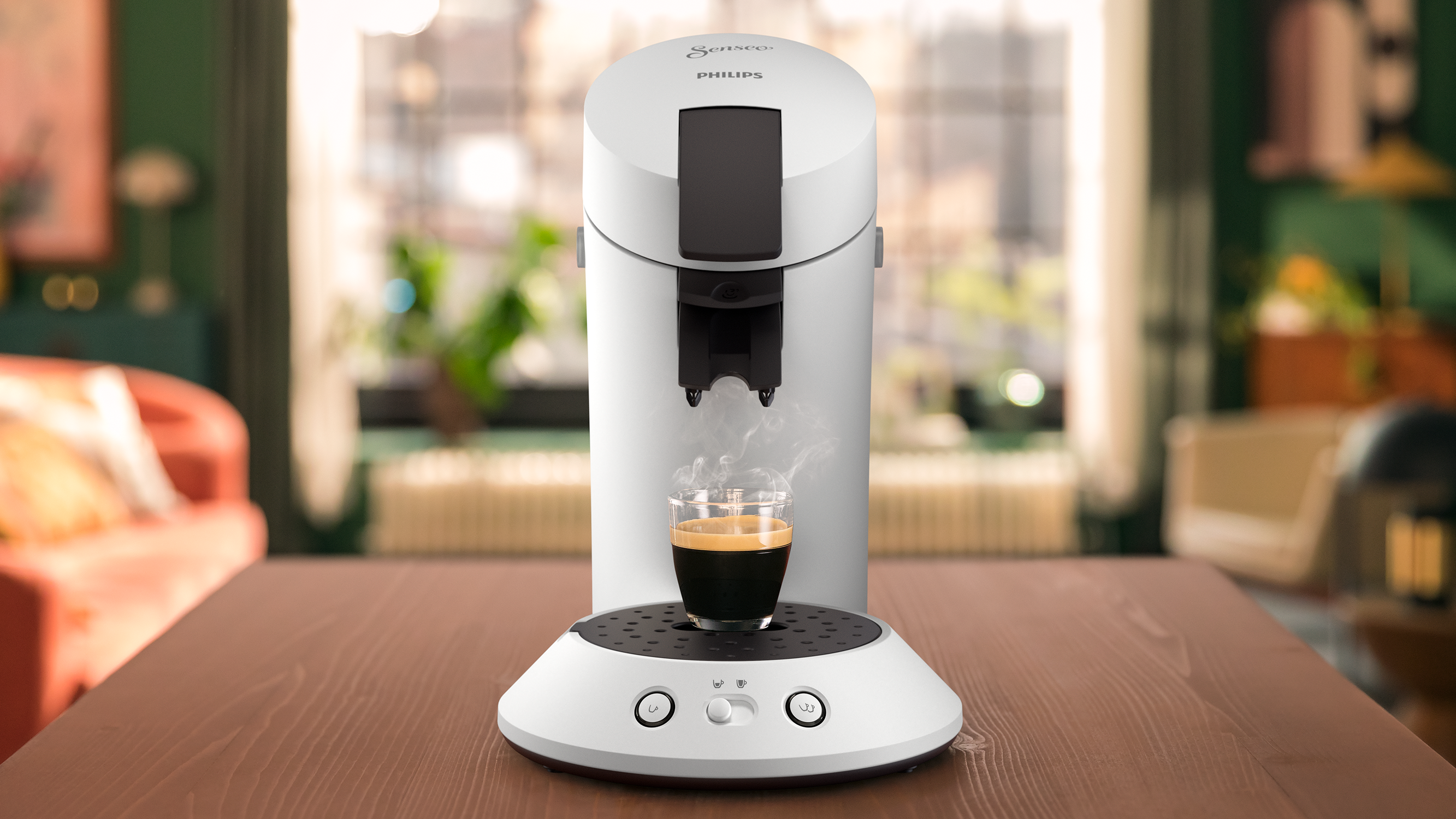A white coffee machine dispensing espresso into a clear glass cup, with steam.