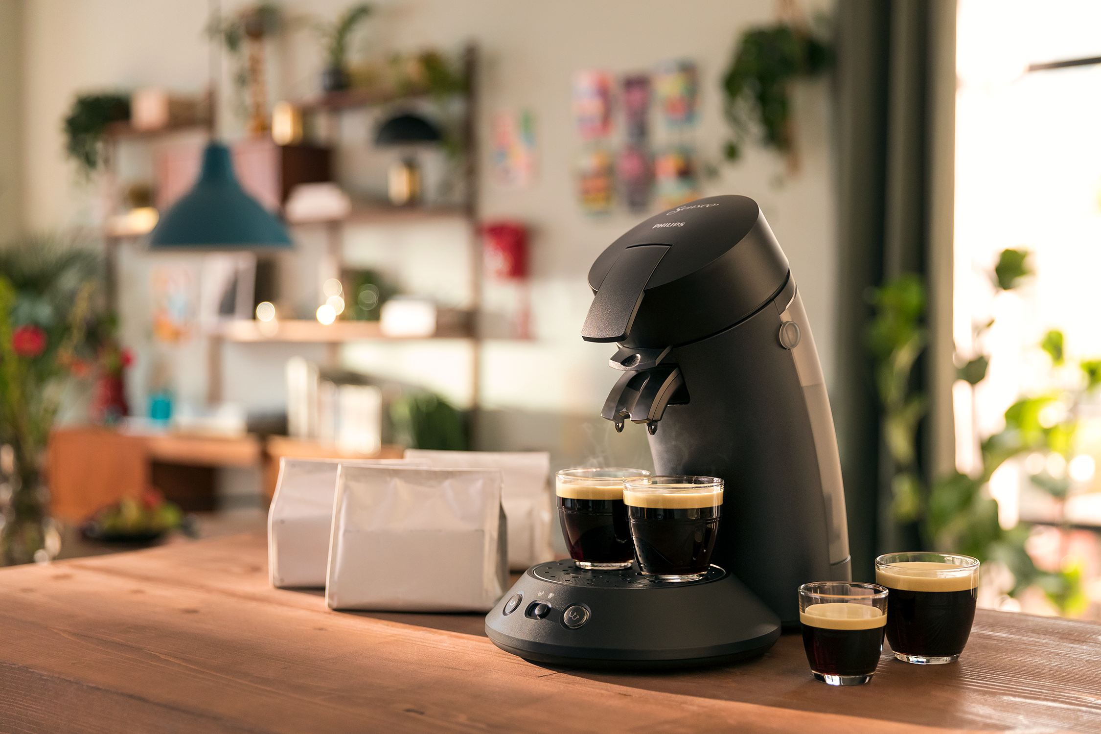 Espresso machine brewing coffee. Two cups are filled. Coffee bags on the table.