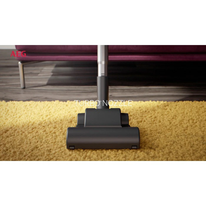 A vacuum cleaner nozzle on a yellow rug. The text 'TURBO NOZZLE' is visible.