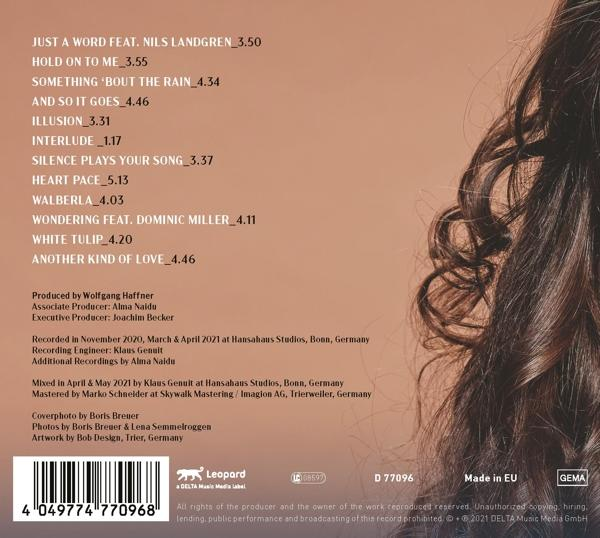 Rückseite einer CD mit einer Liste von Songtiteln und Credits. Das Haar einer Frau ist sichtbar.