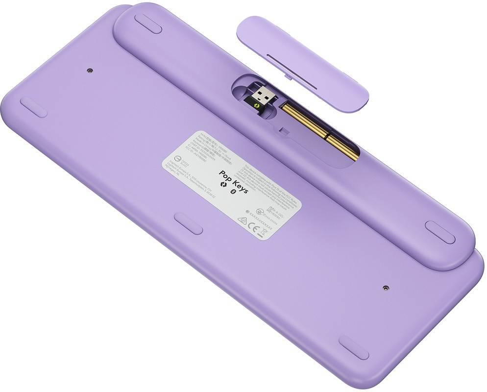 Un clavier violet, avec le compartiment à piles ouvert et le dongle USB visible.