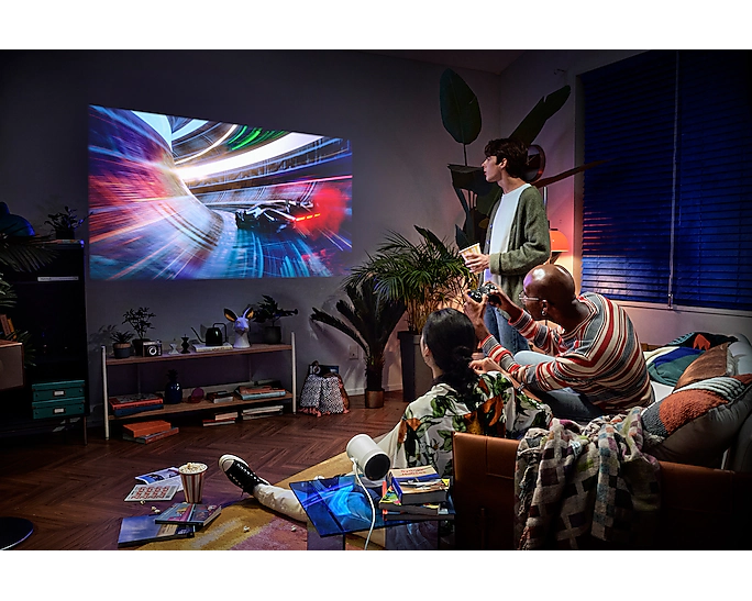 Leute spielen Videospiele, projiziert auf eine Wand. Einer hält einen Controller.