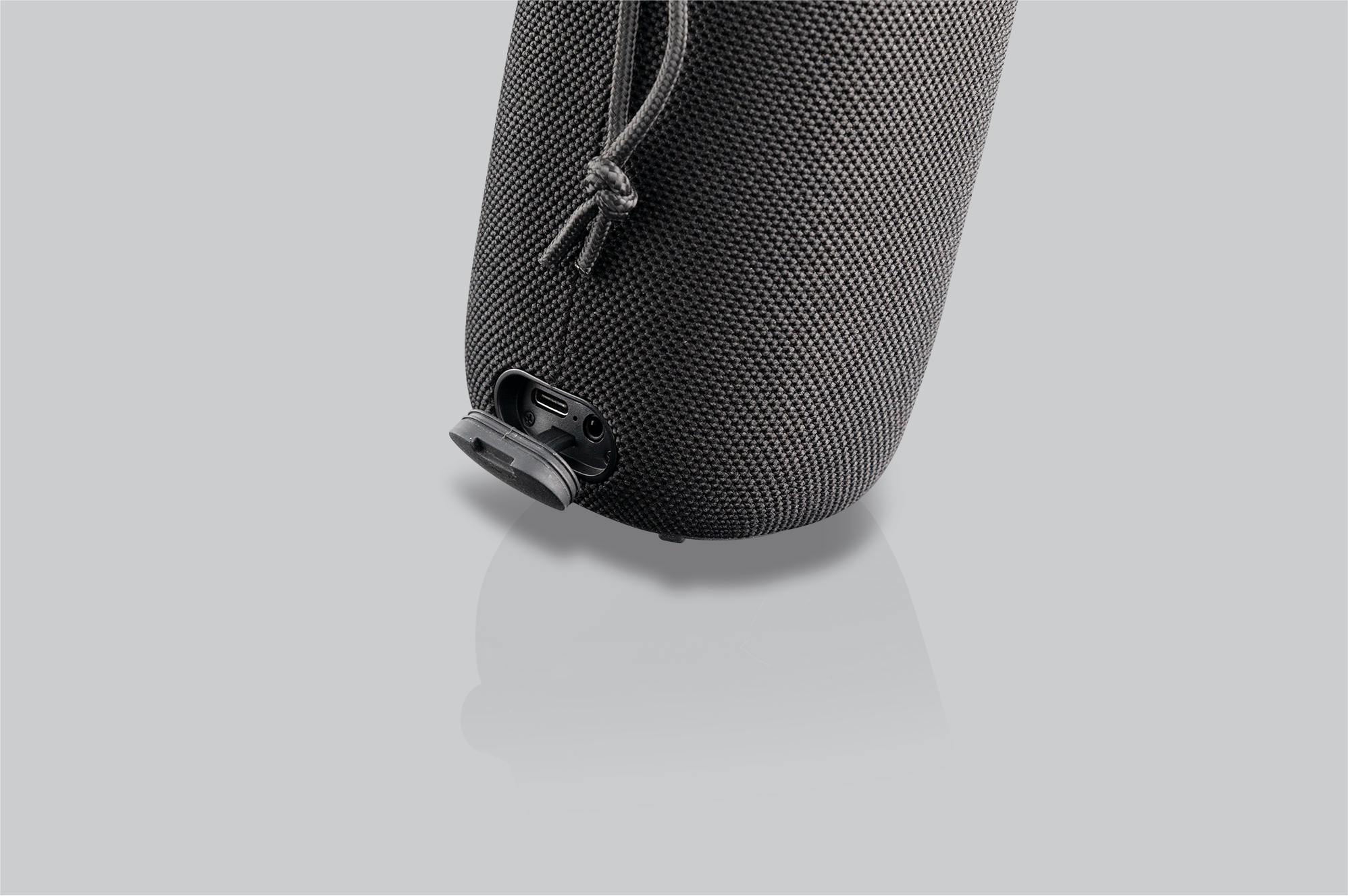 Schwarzer Lautsprecher mit abgedecktem Anschluss an der Seite.