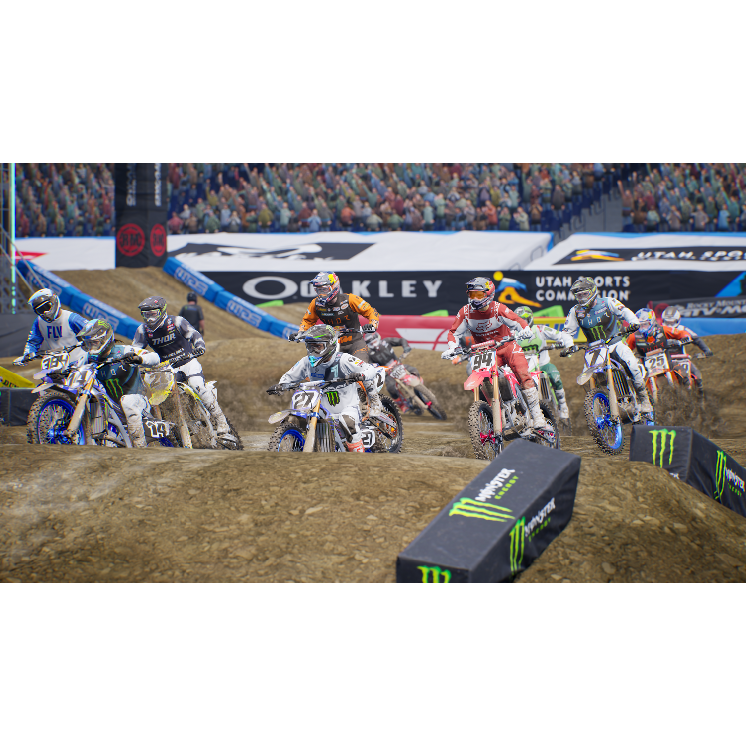 Carrera de motocross con múltiples corredores, compitiendo en una pista de tierra en un estadio.