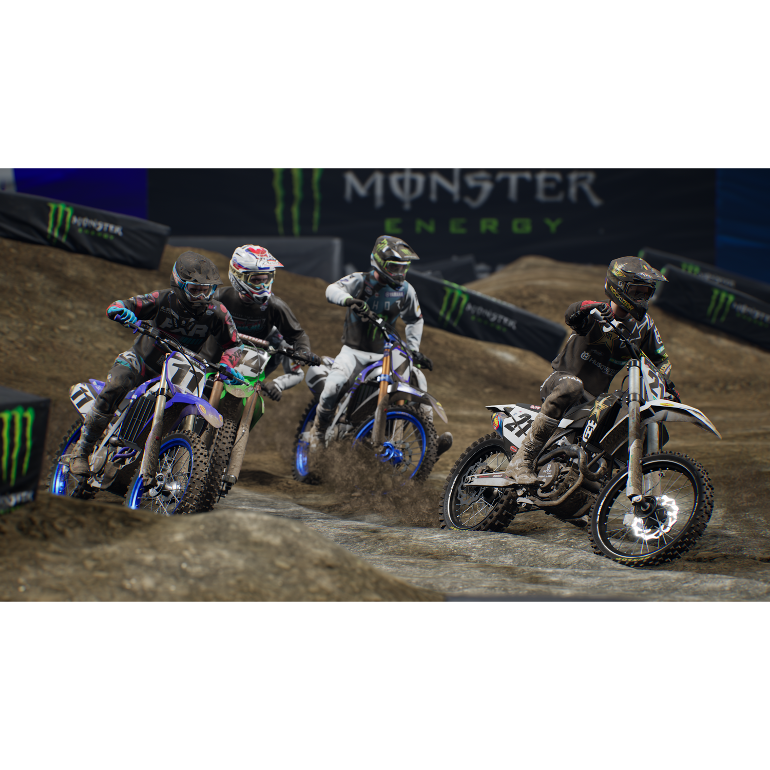 Cuatro pilotos de motocross en motos, levantando polvo en una pista con pancartas de Monster Energy.