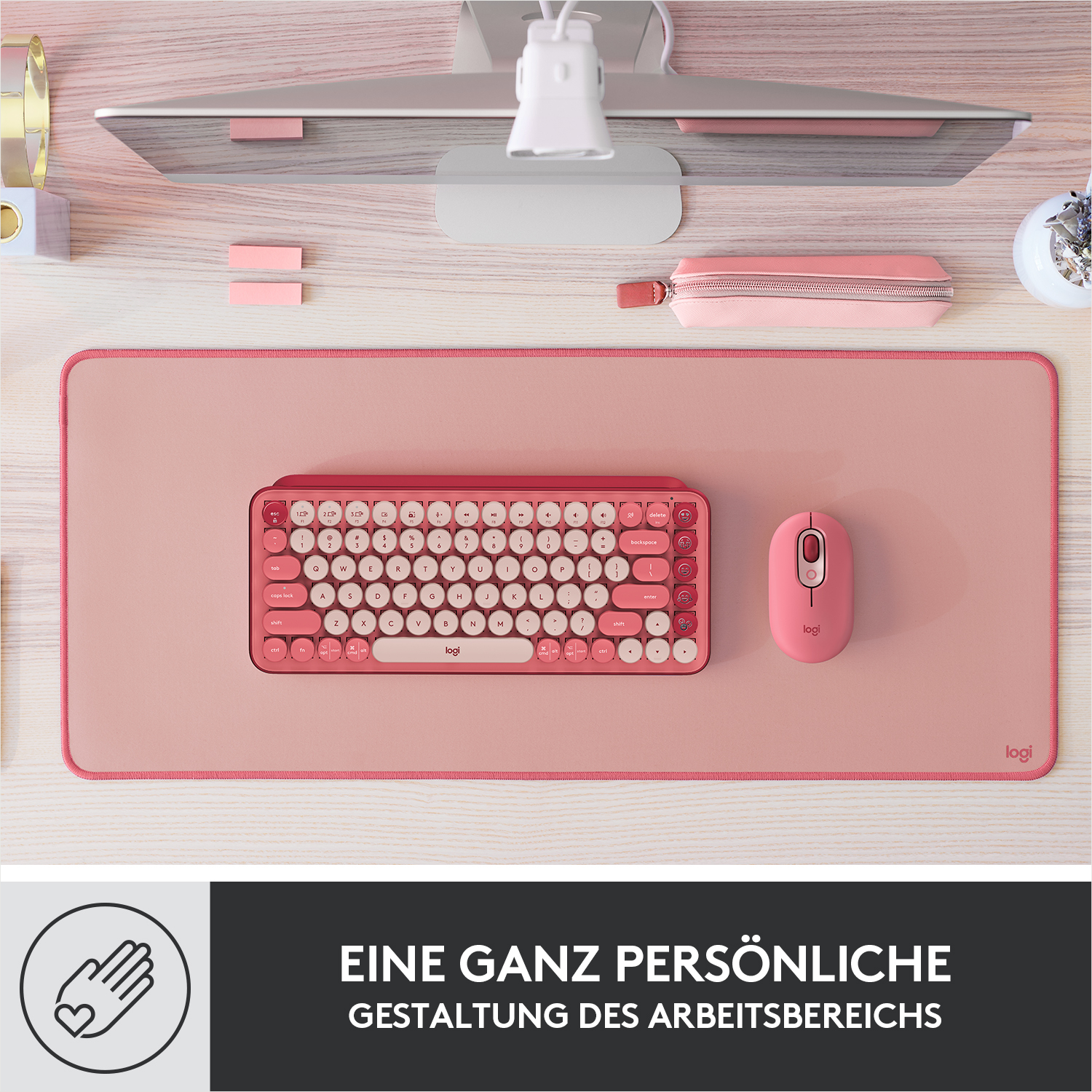 Ein rosa Schreibtisch mit Tastatur, Maus und einem Stifteetui.