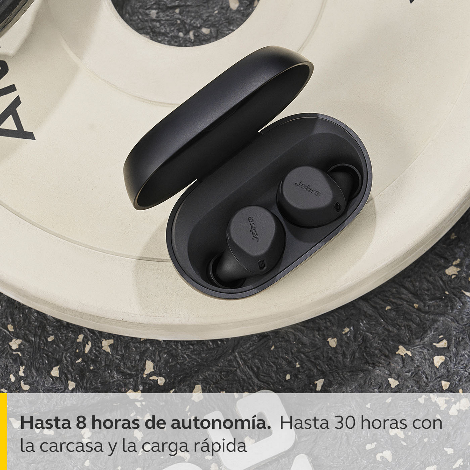 Auriculares Jabra negros en estuche, abiertos, en plato de pesas, texto abajo.