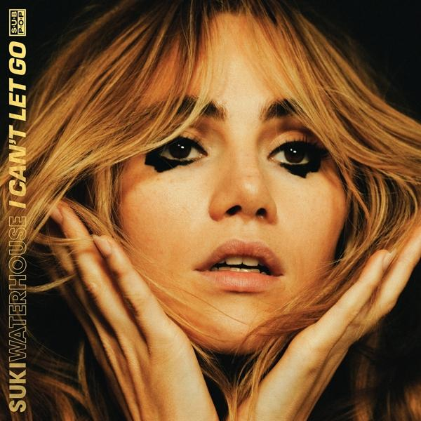 Albumcover mit einem Frauengesicht, dunklem Augen-Make-up und blonden Haaren.