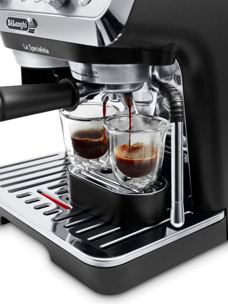 Espressomaschine mit Kaffee, der in zwei Gläser gegossen wird. Schwarze und silberne Maschine.