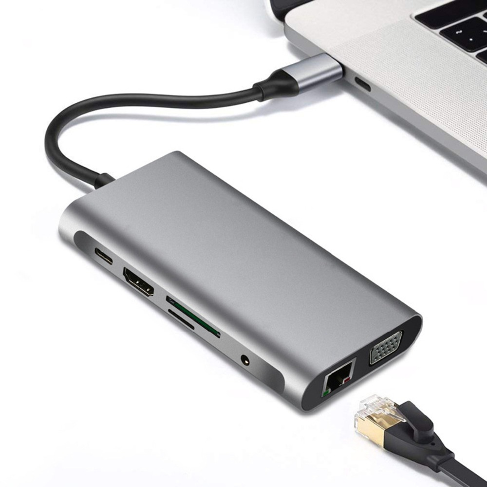 Bir dizüstü bilgisayara bağlı gri bir USB-C hub. HDMI, USB ve Ethernet bağlantı noktalarına sahip.