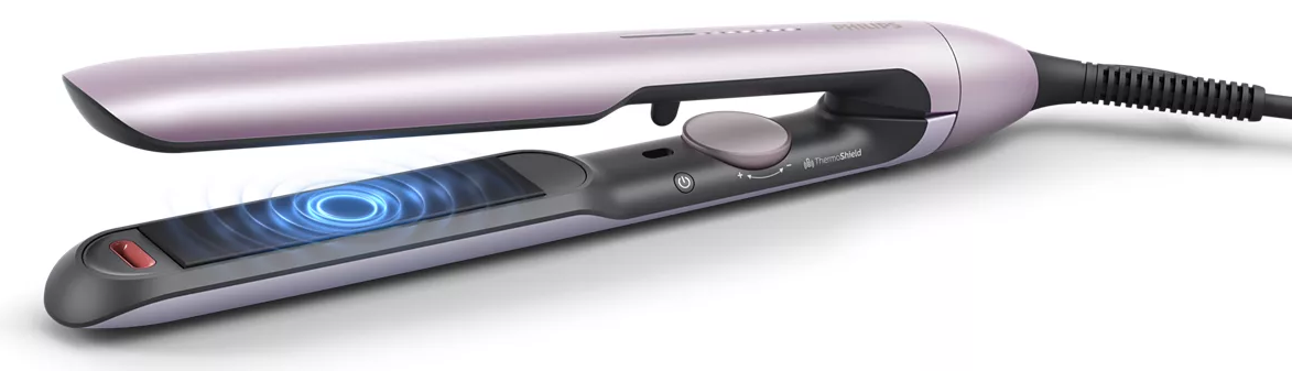 Egy lila hajsimító fekete fogantyúval. Digitális kijelzővel és bekapcsológombbal rendelkezik.