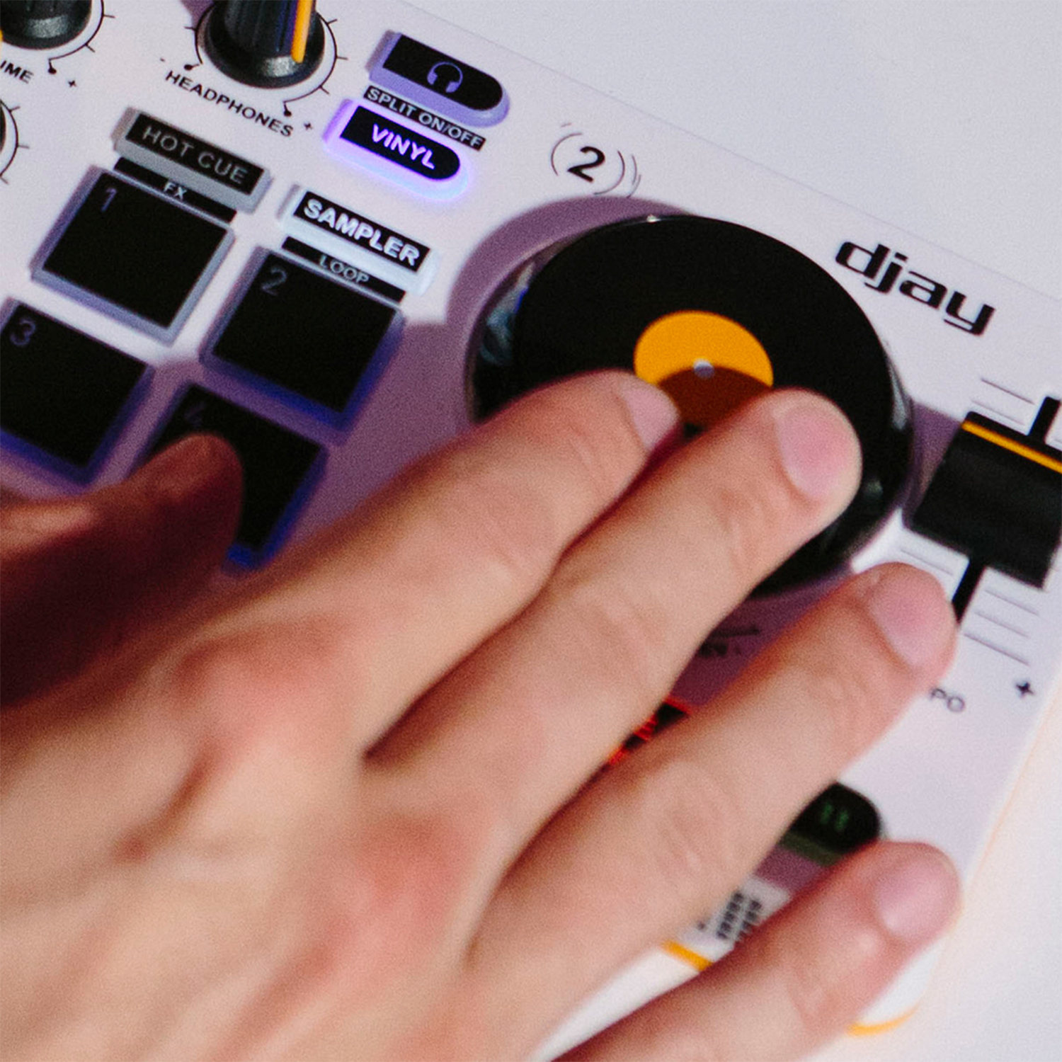 Mani che azionano un controller DJ con pulsanti e una jog wheel in stile vinile.