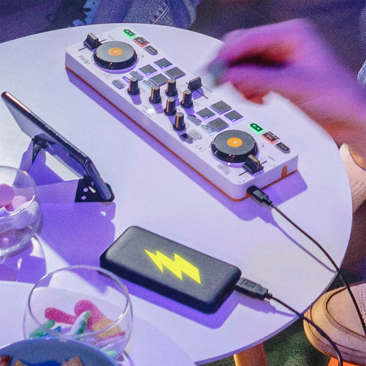 Controller bianco su un tavolo con caricabatterie e telefono neri.