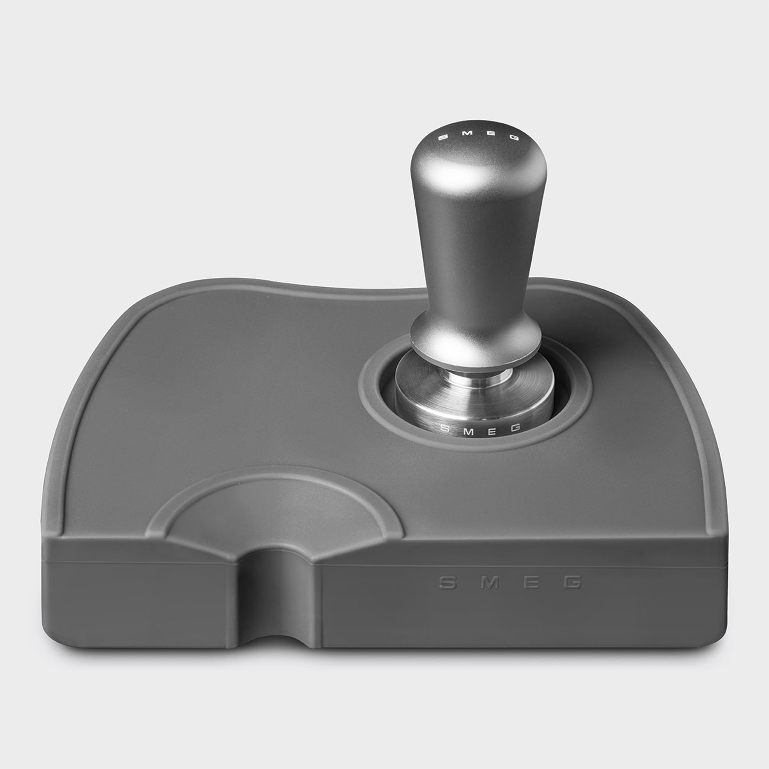 Un pressino per caffè grigio. Ha un manico e una base piatta, su una base grigia.