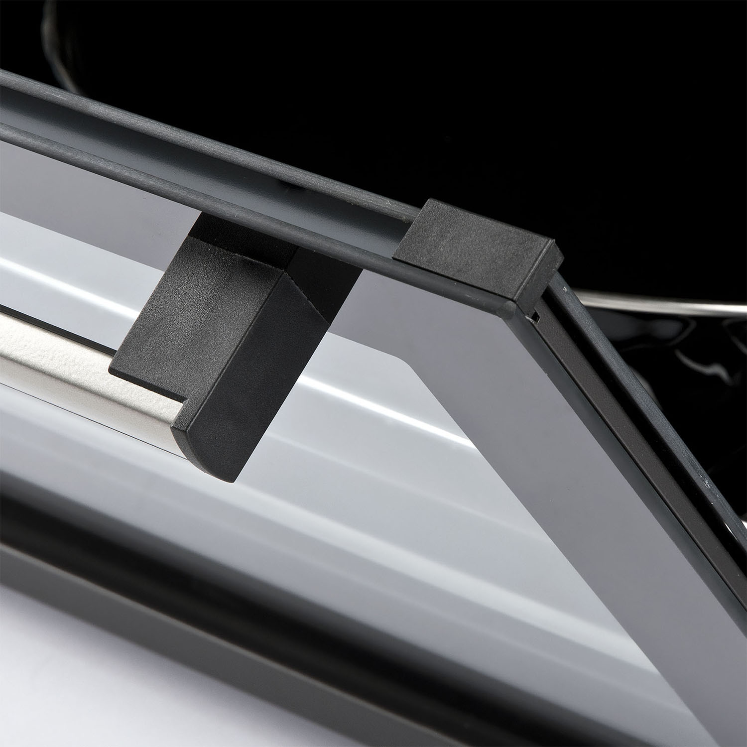 Primo piano di un componente elettronico nero. Il componente è angolato e ha una forma curva.