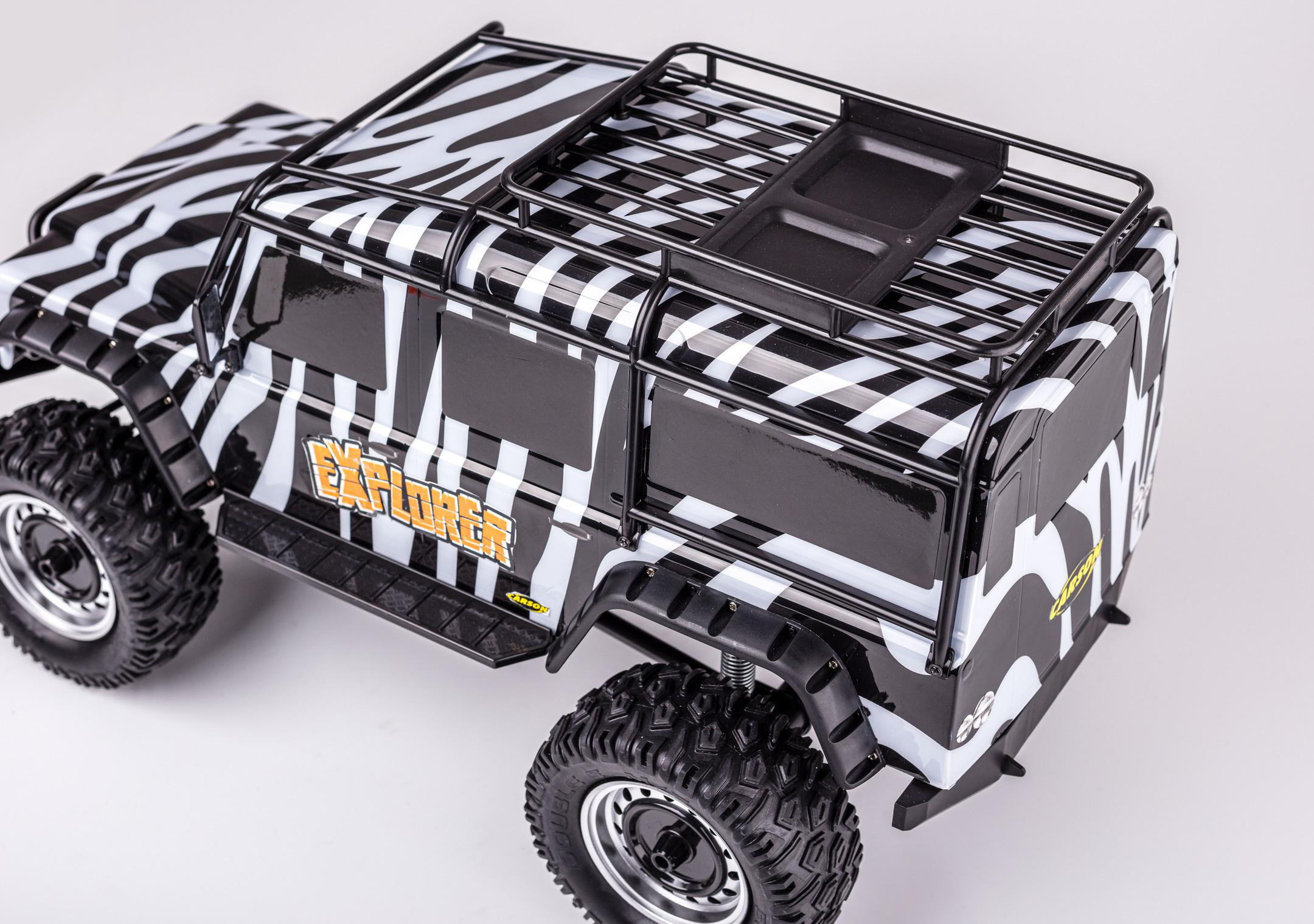 Spielzeug-Geländewagen im Zebrastreifen-Design, schwarzer Dachgepäckträger, weißer Hintergrund.