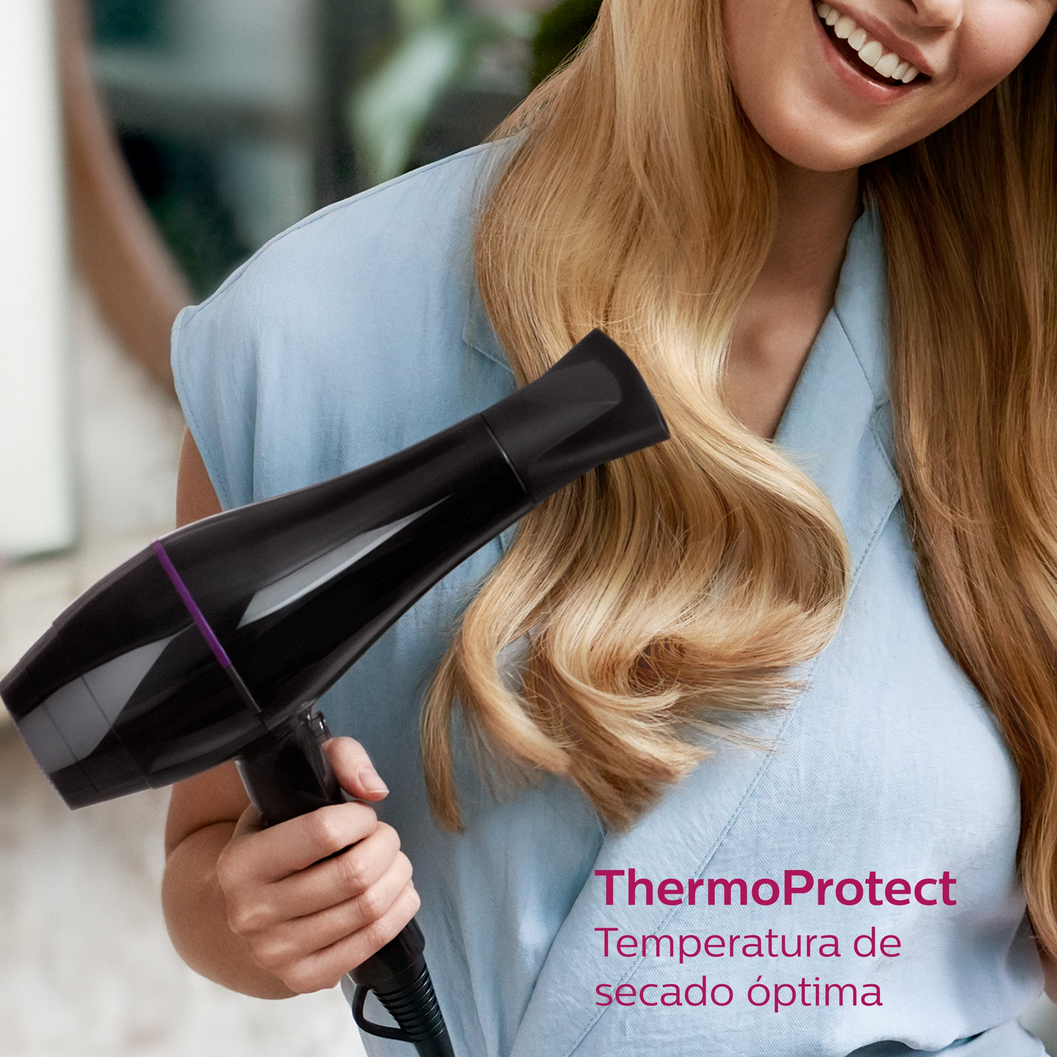 Mujer sonriendo, sosteniendo secador negro. Texto 'ThermoProtect' y 'secado óptimo'.