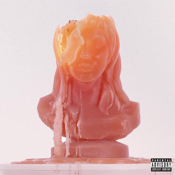 Une statue de buste de bougie avec un visage en cire orange fondu sur une surface rose.