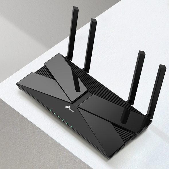 Routeur TP-Link noir, vue de dessus. Quatre antennes, design épuré. Indicateurs lumineux visibles. Surface inclinée.