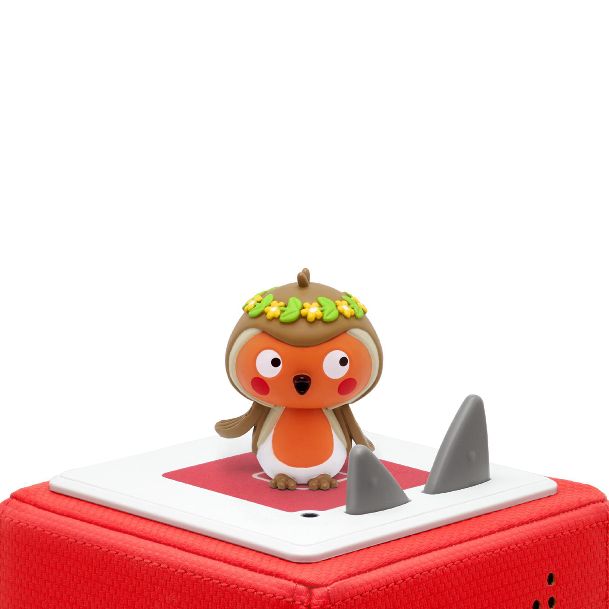 Ein Cartoon-Vogelspielzeug auf einem roten Block mit Haifischflossen, weißer Hintergrund.