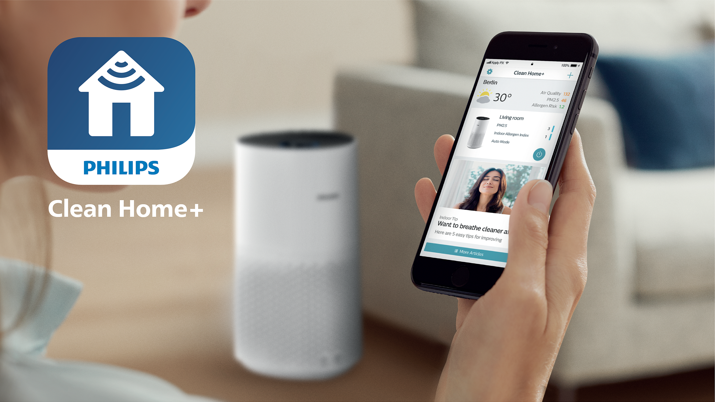 Een persoon die een telefoon vasthoudt met de Philips Clean Home+ app open. Een witte luchtreiniger op de achtergrond.