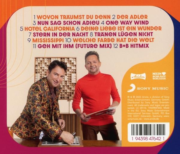 Zwei Männer stehen an einem Tisch, Albumcover in der Hand. Text und Logo im Hintergrund.