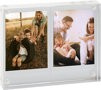 Een dubbele fotolijst. Twee foto's erin. Eén toont kinderen op een schommel, de andere een gezin.
