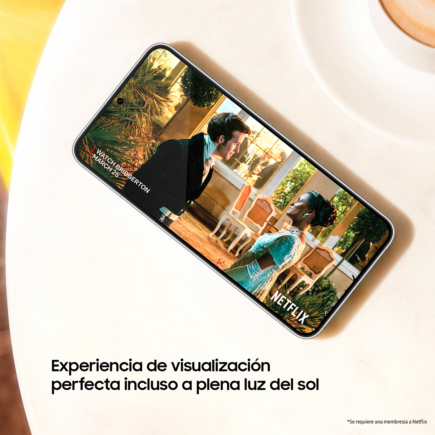 Teléfono muestra video. Texto: Experiencia de visualización perfecta a la luz del sol. Mesa blanca.