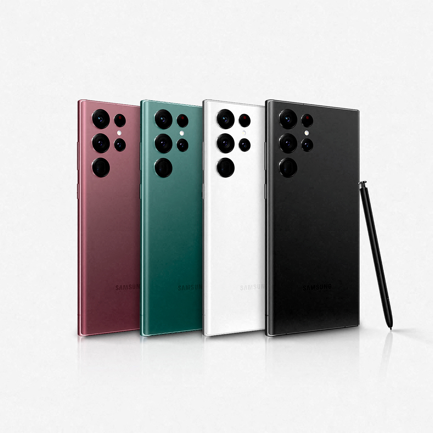 Cuatro teléfonos Samsung de diferentes colores. Negro, verde, blanco y burdeos. Hay un bolígrafo negro junto a ellos.