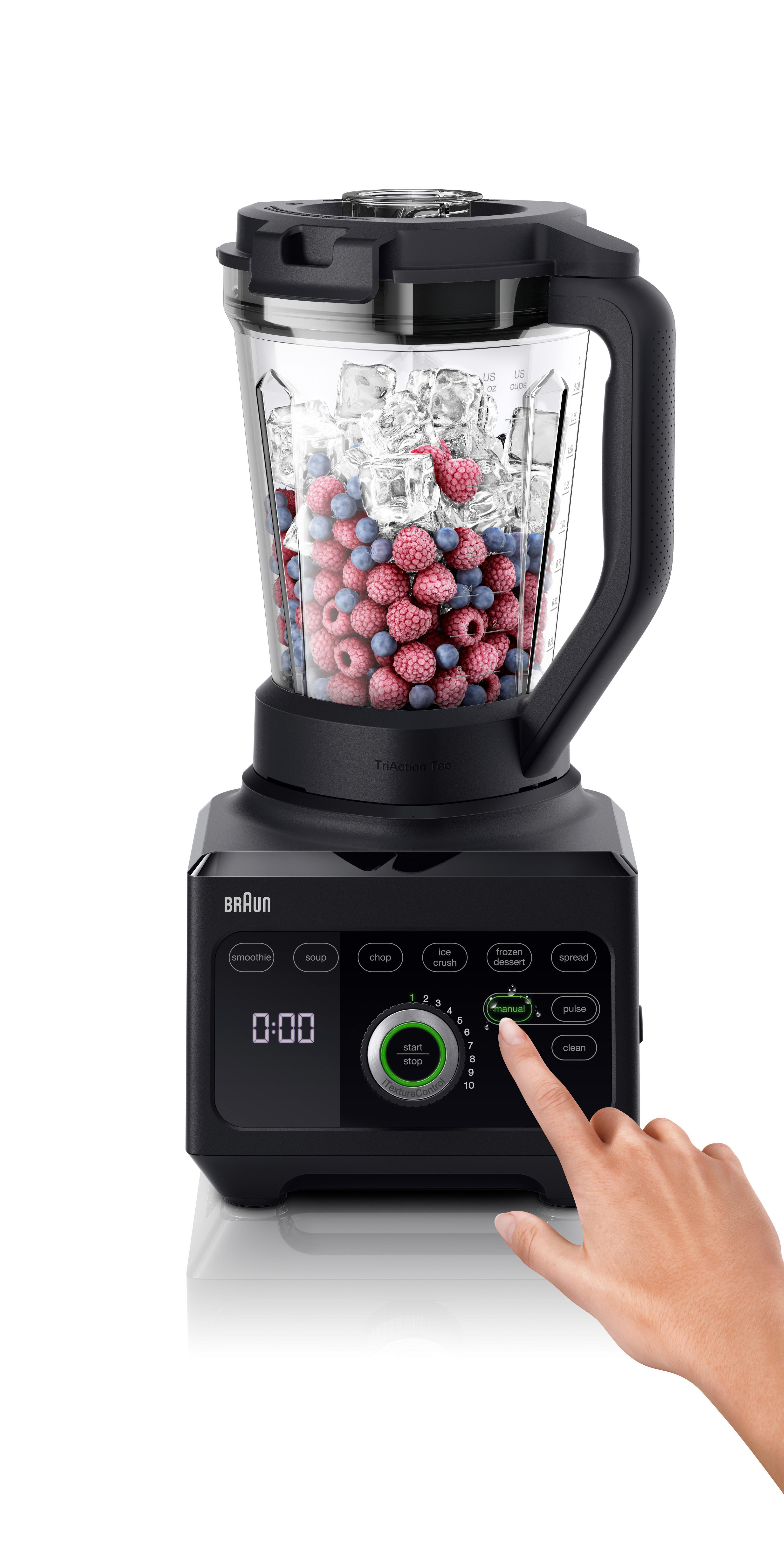 Ein schwarzer Mixer mit einem Glasbehälter, gefüllt mit roten und blauen Früchten und Eiswürfeln.